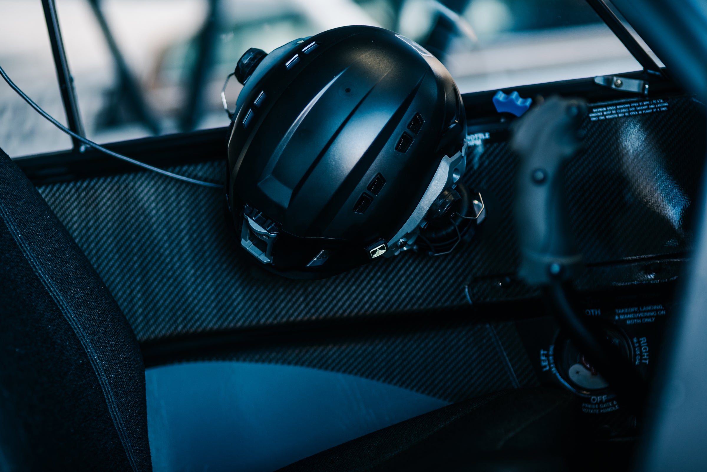 A Sky Cowboy helmet and headset resting in the cockpit